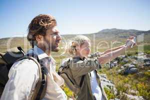 Hiking couple standing on mountain terrain taking a selfie