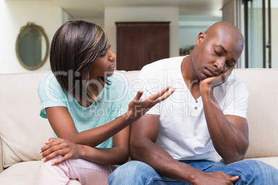 Unhappy couple having an argument on the couch