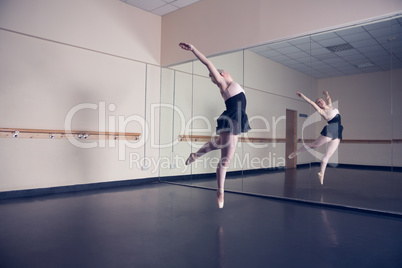 Beautiful ballerina dancing in front of mirror