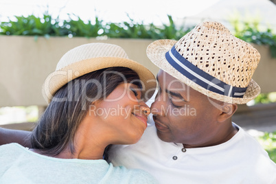 Happy couple lying in garden together cuddling