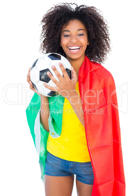 Pretty football fan with portugal flag holding ball