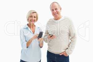 Happy mature couple using their smartphones