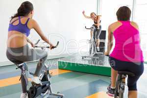 Spin class working out with motivational instructor