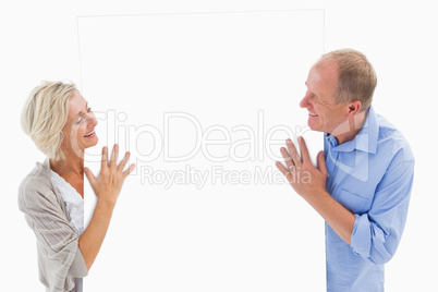 Mature couple smiling and holding card