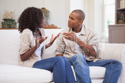 Unhappy couple arguing on the couch