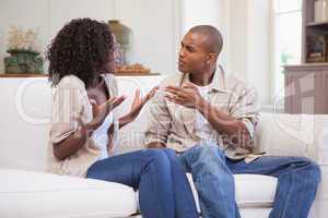 Unhappy couple arguing on the couch