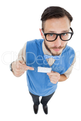 Geeky hipster looking at camera pointing at card