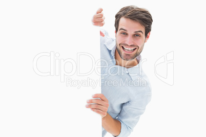 Attractive young man smiling and holding poster