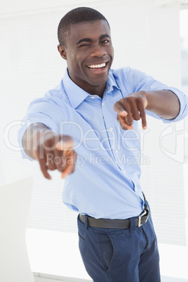 Happy businessman pointing at camera