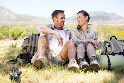 Happy hiking couple taking a break on mountain trail