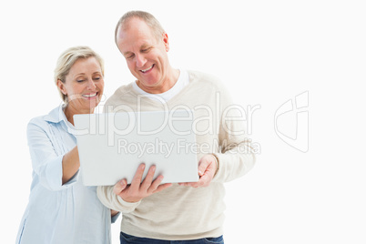 Happy mature couple using laptop