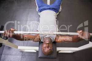 Muscular man lifting barbell in gym