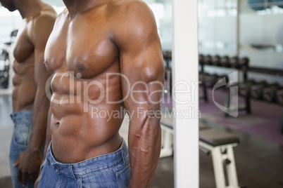 Mid section of a shirtless muscular man in gym