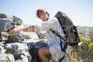 Handsome hiker hiking through rough terrain