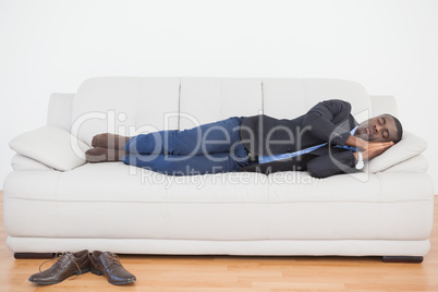 Tired businessman sleeping on sofa