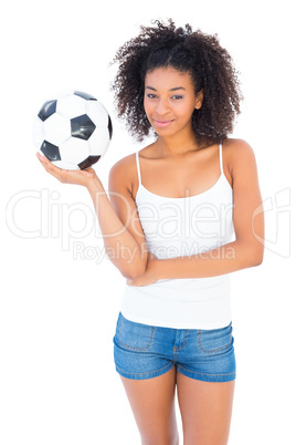 Pretty girl holding football and smiling at camera