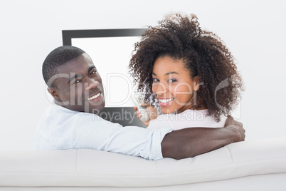 Couple sitting on couch together watching tv