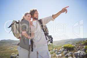 Hiking couple standing on mountain terrain looking around