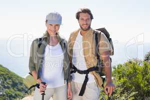 Hiking couple smiling at camera at mountain summit