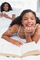 Happy mother and daughter relaxing on bed together