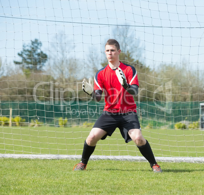 Goalkeeper in red ready to make a save