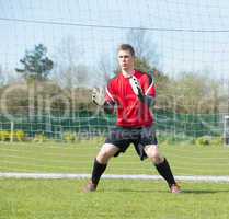 Goalkeeper in red ready to make a save