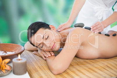 Beautiful brunette enjoying a hot stone massage