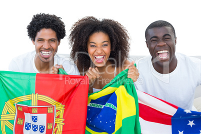 Happy football fans holding flags smiling at camera