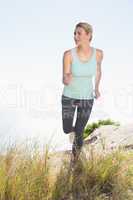 Fit blonde jogging on mountain trail