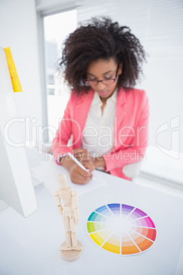 Casual graphic designer working at her desk sketching