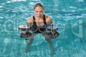 Fit blonde working out with foam dumbbells