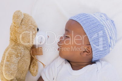 Adorable baby boy sleeping peacefully with teddy