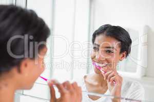 Pretty woman brushing her teeth