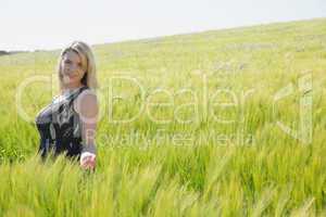 Pretty blonde in sundress standing in wheat field