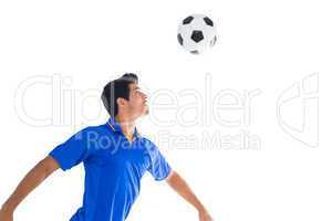 Football player in blue heading ball