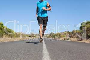 Athletic man jogging on open road