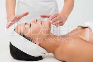 Peaceful brunette getting reiki therapy