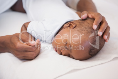 Baby boy sleeping peacefully on couch with father