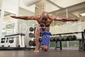 Bodybuilder with arms outstretched in gym