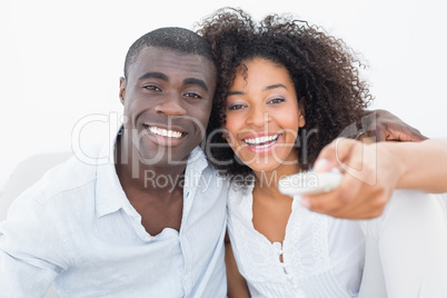 Couple sitting on couch together watching tv