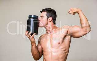 Muscular man kissing nutritional supplement
