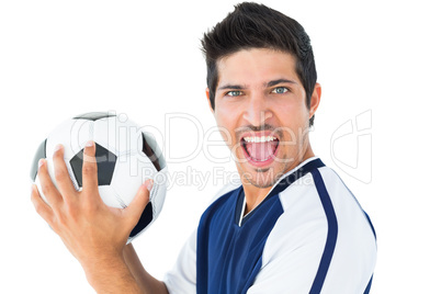 Happy football player in blue holding the ball