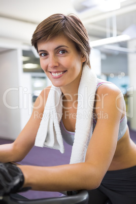 Fit smiling woman working out on the exercise bike