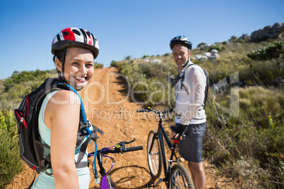 Active couple cycling on country terrain together