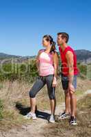 Active couple standing on country terrain