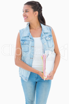 Pretty student smiling and holding notepads