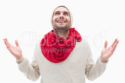 Attractive young man in warm clothes with hands up