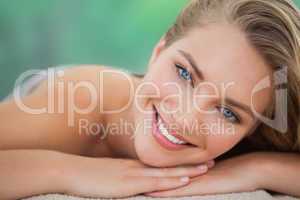 Peaceful blonde lying on towel smiling at camera