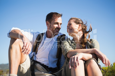 Hiking couple sitting and smiling at each other