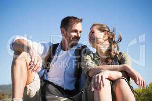 Hiking couple sitting and smiling at each other